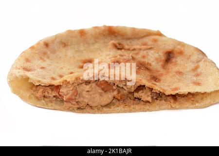 Un pain plat avec des fèves de fava écrasées mélangées à l'huile, tahini de sésame, cumin, épices, foyer sélectif de traditionnel populaire sandwich de haricots égyptiens isolat Banque D'Images