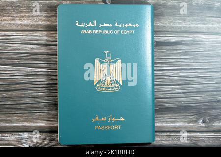 Passeport égyptien isolé sur fond de bois, passeport de la république arabe d'Égypte avec l'aigle d'or républicain sur sa couverture et le roi Toutankhamon Banque D'Images