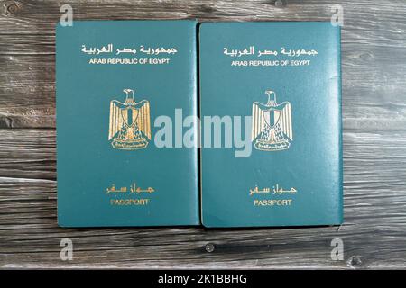 Passeport égyptien isolé sur fond de bois, passeport de la république arabe d'Égypte avec l'aigle d'or républicain sur sa couverture et le roi Toutankhamon Banque D'Images