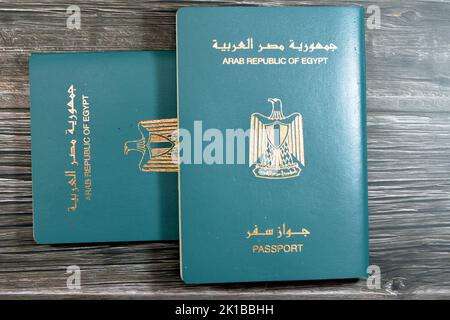 Passeport égyptien isolé sur fond de bois, passeport de la république arabe d'Égypte avec l'aigle d'or républicain sur sa couverture et le roi Toutankhamon Banque D'Images