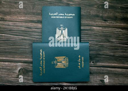 Passeport égyptien isolé sur fond de bois, passeport de la république arabe d'Égypte avec l'aigle d'or républicain sur sa couverture et le roi Toutankhamon Banque D'Images