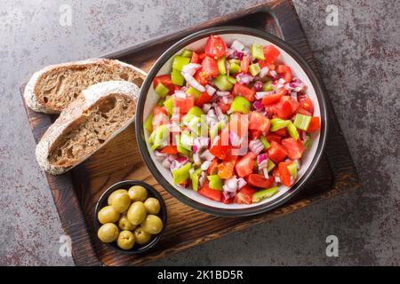 L'été à Majorque salade Trampo est construit sur une base de tomate, poivrons verts et oignons sur le panneau de bois sur la table. Vue horizontale du dessus f Banque D'Images