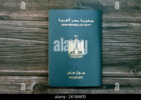 Passeport égyptien isolé sur fond de bois, passeport de la république arabe d'Égypte avec l'aigle d'or républicain sur sa couverture et le roi Toutankhamon Banque D'Images