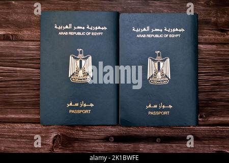 Passeport égyptien isolé sur fond de bois, passeport de la république arabe d'Égypte avec l'aigle d'or républicain sur sa couverture et le roi Toutankhamon Banque D'Images