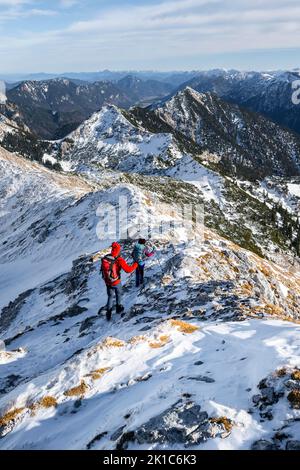 Deux alpinistes sur l'étroite crête rocheuse enneigée de l'Ammergauer Hochplatte, vue panoramique sur la montagne, randonnée jusqu'à l'Ammergauer Hochplatte, in Banque D'Images