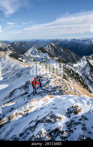 Deux alpinistes sur l'étroite crête rocheuse enneigée de l'Ammergauer Hochplatte, vue panoramique sur la montagne, randonnée jusqu'à l'Ammergauer Hochplatte, in Banque D'Images