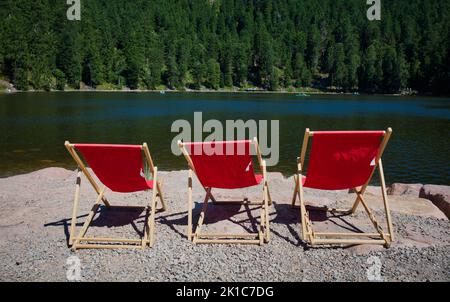 Trois chaises longues rouges vides, Mummelsee, Seebach, Parc national de la Forêt-Noire, Bade-Wurtemberg, Allemagne Banque D'Images