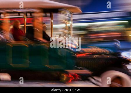 Touristes en voiture d'époque à travers le centre-ville de San Francisco, motion blur, lumières colorées au néon dans la soirée, Californie, États-Unis Banque D'Images