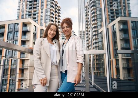 Des femmes d'affaires souriantes et confiantes qui se posent pour l'extérieur Banque D'Images