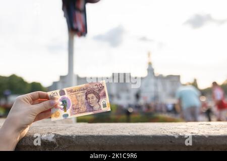 Londres, Royaume-Uni - 11 septembre 2022: Billet de banque Royaume-Uni 20 livres d'Elizabeth II devant le palais de Buckingham à l'annonce de sa mort Banque D'Images