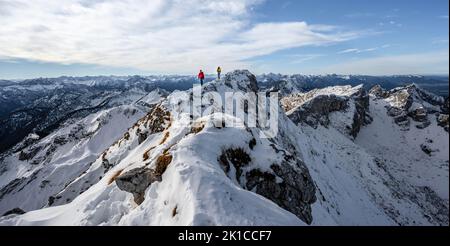 Deux alpinistes sur une étroite crête rocheuse enneigée, derrière le corbeau de pic, vue sur la montagne panoramique, randonnée à Ammergauer Hochplatte, en automne, Ammergau Banque D'Images