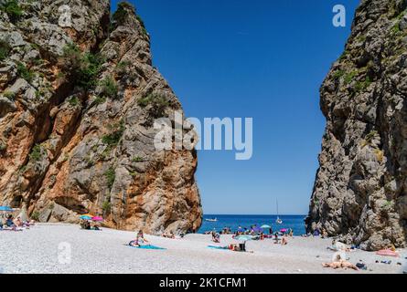 Touristes sur la plage de galets, Torrent de Pareis, sa Calobra, Majorque, Iles Baléares, Espagne. Banque D'Images