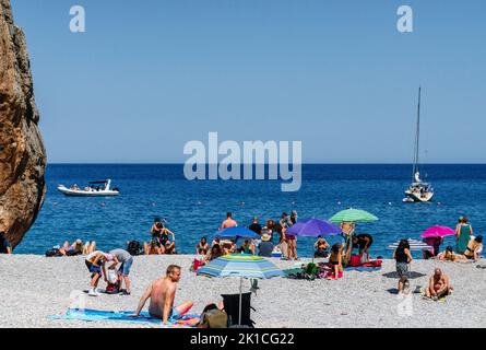 Touristes sur la plage de galets, Torrent de Pareis, sa Calobra, Majorque, Iles Baléares, Espagne. Banque D'Images