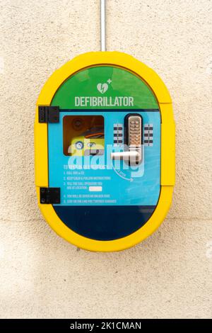 Défibrillateur automatisé portable de sauvetage (AED) monté sur le mur d'un village en Angleterre Banque D'Images