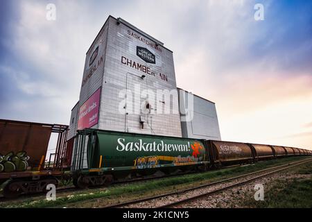 Une vue à angle bas de l'élévateur de grain à Chamberlain, en Saskatchewan, au Canada, avec un train qui passe devant Banque D'Images