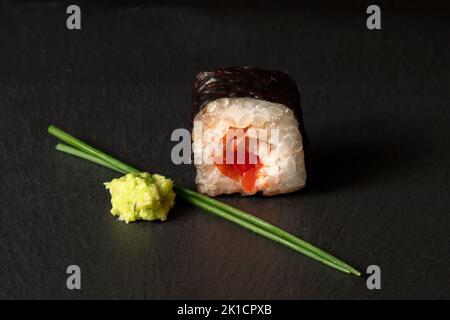 Roul de sushi hosomaki au poivre rouge avec wasabi et ciboulette Banque D'Images