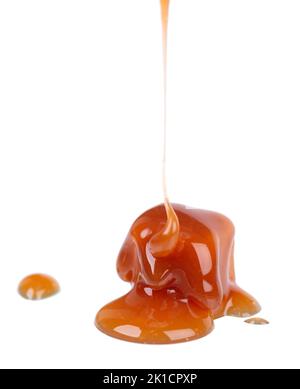 Sucreries et sauce au caramel doux, isolées sur fond blanc. Délicieux caramel Banque D'Images