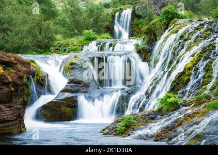 Belle cascade de Gjain s'écoulant dans une jungle luxuriante dans la vallée de Pjorsardalur en été au sud de l'Islande Banque D'Images