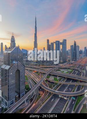 Lever de soleil sur le centre-ville de Dubaï avec la Burj Khalifa et l'emblématique échangeur Sheikh Zayed Road, avec les gratte-ciel modernes de la ville Banque D'Images