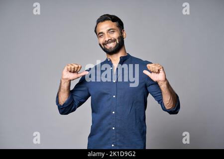 Homme d'affaires indien souriant, isolé sur fond gris, pointant vers lui-même. Banque D'Images