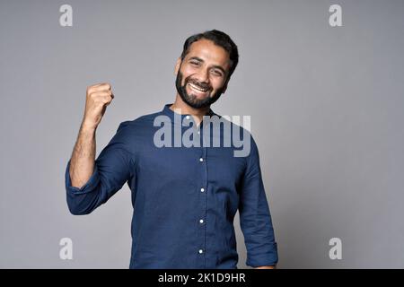Un riche investisseur indien heureux qui se hissent le poing isolé sur fond gris. Banque D'Images