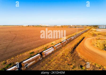 Train de fret à grain long sur le site de stockage des silos dans la ville de Moree, dans le bassin artésien australien. Banque D'Images