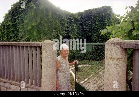 Greci, Comté de Tulcea, Roumanie, 2000. Femme âgée de la petite communauté italienne, avec un nom de famille italien sculpté par la porte. Banque D'Images