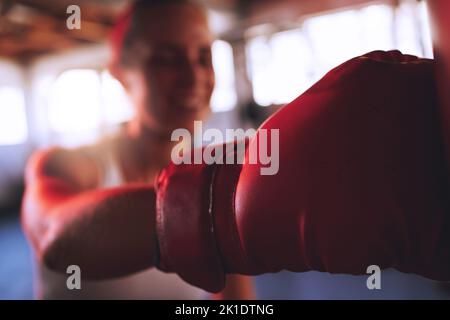 Boxe, fitness et sport avec femme forte, gants de boxe à frapper, punch et combattre pendant l'entraînement dans une salle de gym. Coupe et boxeur sportif femme faisant un wor Banque D'Images