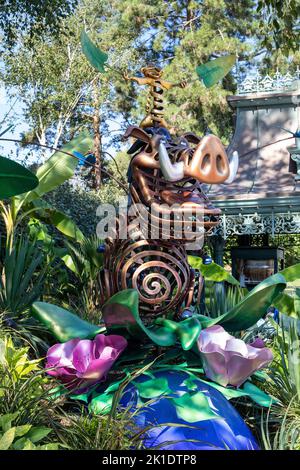 Une photo verticale d'un personnage de dessin animé Disney Pumbaa sculpturedans un jardin de Disneyland, France Banque D'Images