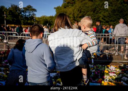 Windsor, Royaume-Uni. 17th septembre 2022. Une famille voit les hommages floraux à l'extérieur du château de Windsor. Des foules de touristes et de bien-être du monde entier continuent de venir au château de Windsor pour rendre hommage à la reine Elizabeth II, décédée le 8th septembre 2022. Crédit : SOPA Images Limited/Alamy Live News Banque D'Images