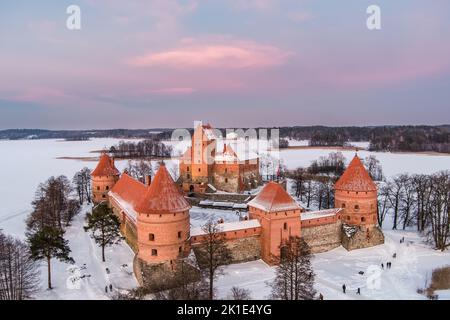 Belle vue aérienne du château de l'île Trakai, situé à Trakai, Lituanie. Lac Galve gelé recouvert de neige au lever du soleil d'hiver. Pittoresque hiver sce Banque D'Images