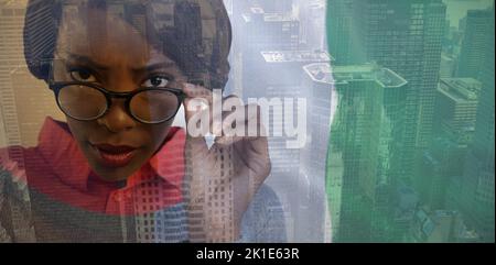 Portrait de la jeune femme portant des lunettes contre l'image d'un paysage urbain Banque D'Images