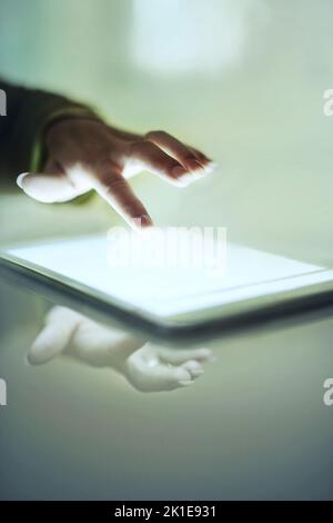 Technologie intuitive. Gros plan court d'une main de femme au-dessus d'une tablette numérique. Banque D'Images