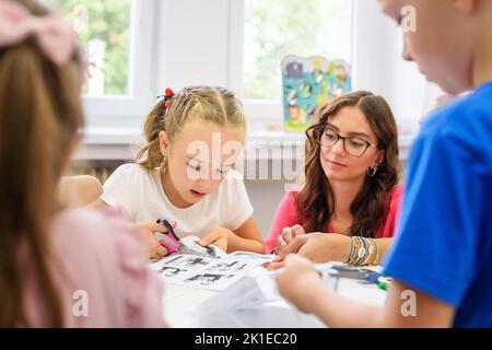 Séance d'ergothérapie pour enfants. Groupe d'enfants faisant des exercices ludiques avec leur thérapeute. Banque D'Images