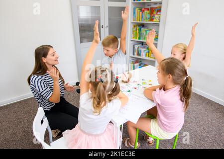 Séance d'ergothérapie pour enfants. Groupe d'enfants faisant des exercices ludiques avec leur thérapeute. Banque D'Images