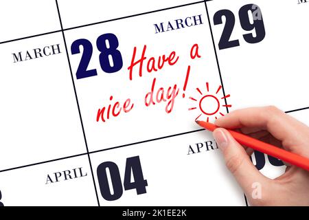 28th jour de mars. La main écrivant le texte ont une belle journée et dessinant le soleil sur la date calendrier 28 mars. Enregistrez la date. Mois de printemps, jour du TH Banque D'Images