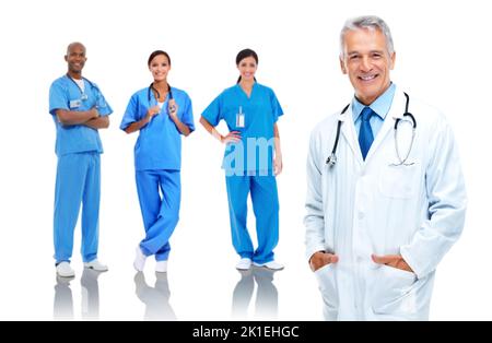 Le meilleur en médecine. Photo studio d'un médecin senior avec trois infirmières debout derrière lui Banque D'Images