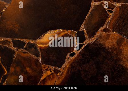 Oeil de tigre en pierre avec une couleur jaune dorée et marron. Texture comme arrière-plan précieux. Mat minéral beau avec soyeux brillant Banque D'Images