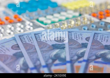 Photo du concept DU système DE santé AMÉRICAIN. L'expensivité de l'assurance maladie. DOLLARS AMÉRICAINS et pilules. Mise au point sélective sur le premier plan. Banque D'Images