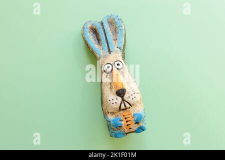 Yeux choqués du lièvre sur fond vert avec espace de copie. Jouet de lapin, symbole de la nouvelle année 2023. Banque D'Images