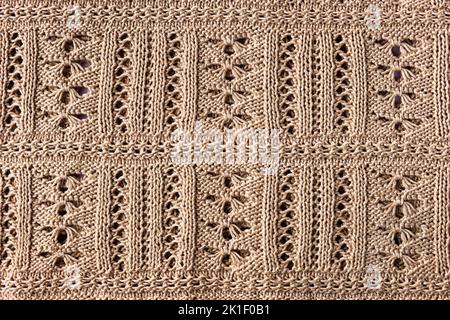 Arrière-plan beige tricoté. Grand tissu tricoté avec un motif. Gros plan d'une couverture tricotée Banque D'Images