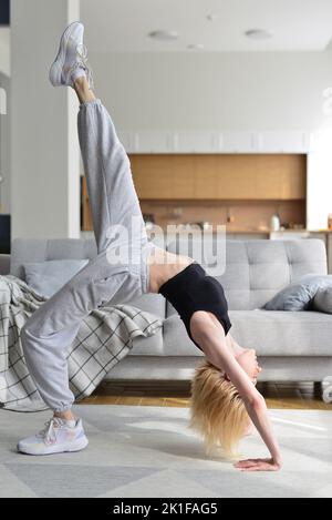 La femme effectue un exercice de pont à la maison Banque D'Images