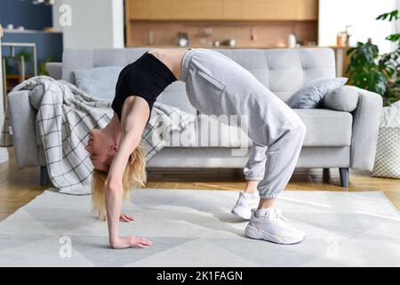 La femme effectue un exercice de pont à la maison Banque D'Images