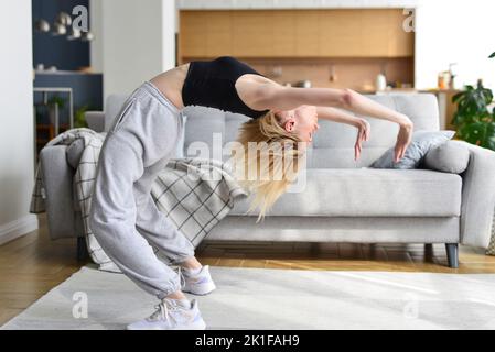 La femme effectue un exercice de pont à la maison Banque D'Images