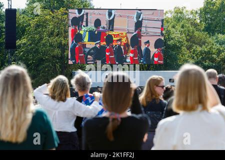 Les foules à Hyde Park sont photographiées en regardant le cercueil de sa Majesté la Reine transporté au Palais de Westminster sur de grands écrans vidéo. Banque D'Images