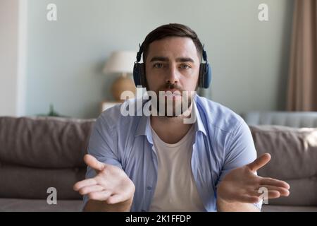 Homme charmant millénaire dans un casque sans fil tête tourné en portrait Banque D'Images