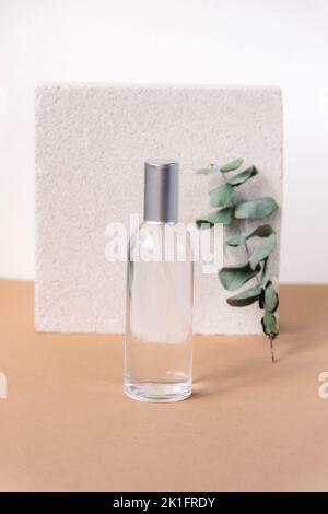 Branche cosmétique tonique et eucalyptus sur table beige sur fond de pierre naturelle. Concept de soin de la peau. Banque D'Images