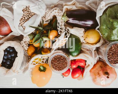 Fruits et légumes frais dans des sacs de coton écologique et céréales dans des pots en verre sur une table dans la cuisine.Concept d'achat sans gaspillage.Vue de dessus.Pose à plat Banque D'Images