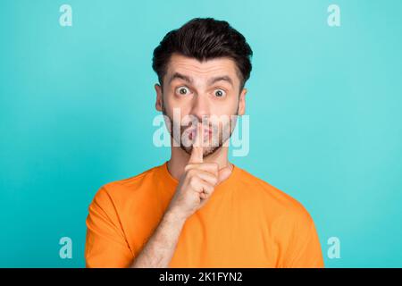 Photo de jeune attrayant beau drôle de gars étudiant point de doigt de couverture lèvres shh silence information secrète isolée sur fond bleu-vert couleur Banque D'Images