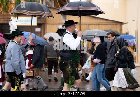 18 septembre 2022, Bavière, Munich : les visiteurs de l'Oktoberfest se promornent sur le terrain avec des parasols. Photo: Sven Hoppe/dpa Banque D'Images